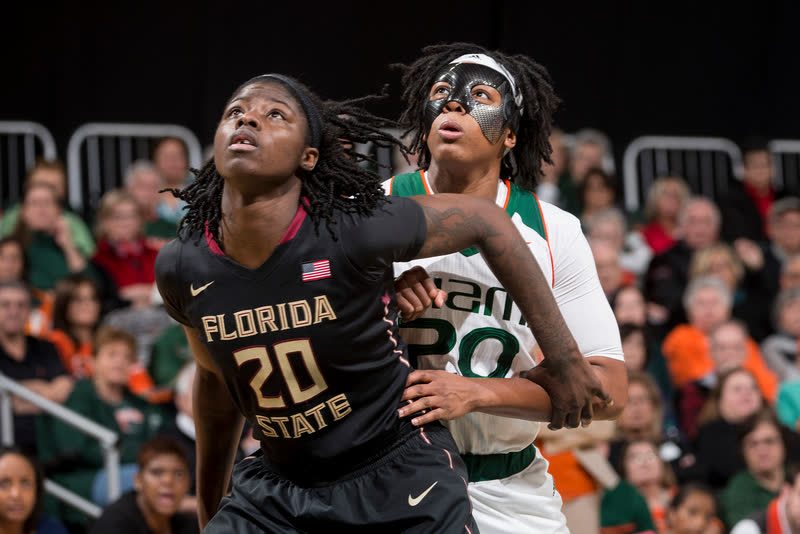 Keyona Hayes playing basketball for the Miami Hurricanes in her custom protective face mask